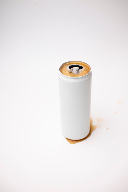 Free A white soda can with spilled beverage on a clean surface, representing simplicity and minimalism. Stock Photo
