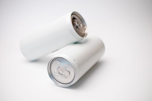 Free Close-up of two blank aluminum cans on a white background, perfect for branding mockups. Stock Photo