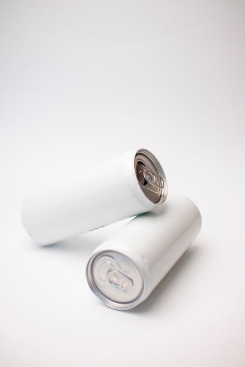 Free A minimalist photo of two blank white cans on a plain surface, ideal for mockup designs. Stock Photo