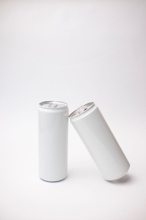 Two unbranded beverage cans on a pale surface — photo by Леся Терехова on Pexels