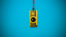 蓝色背景上有一个充满活力的黄色相机钥匙扣与挂绳