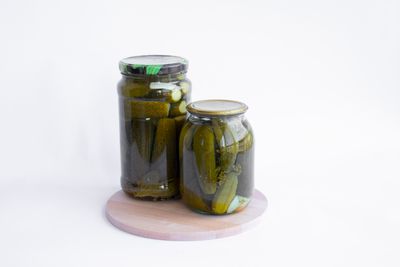 Upright jars of pickled cucumbers on a wooden board — photo by Леся Терехова on Pexels