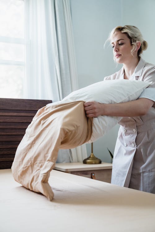 Woman Putting Pillowcase on a Pillow