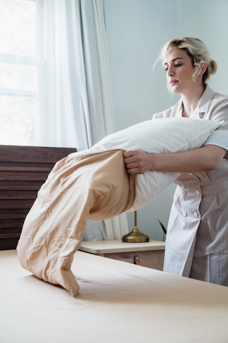 Woman Putting Pillowcase On A Pillow