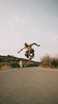 Skateboarder performs an impressive trick on a sunny road in Vasto, Italy.