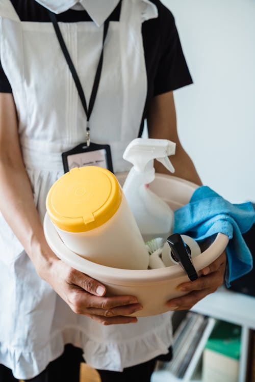 Woman Holding A Plastic Basin With Cleaning Materials