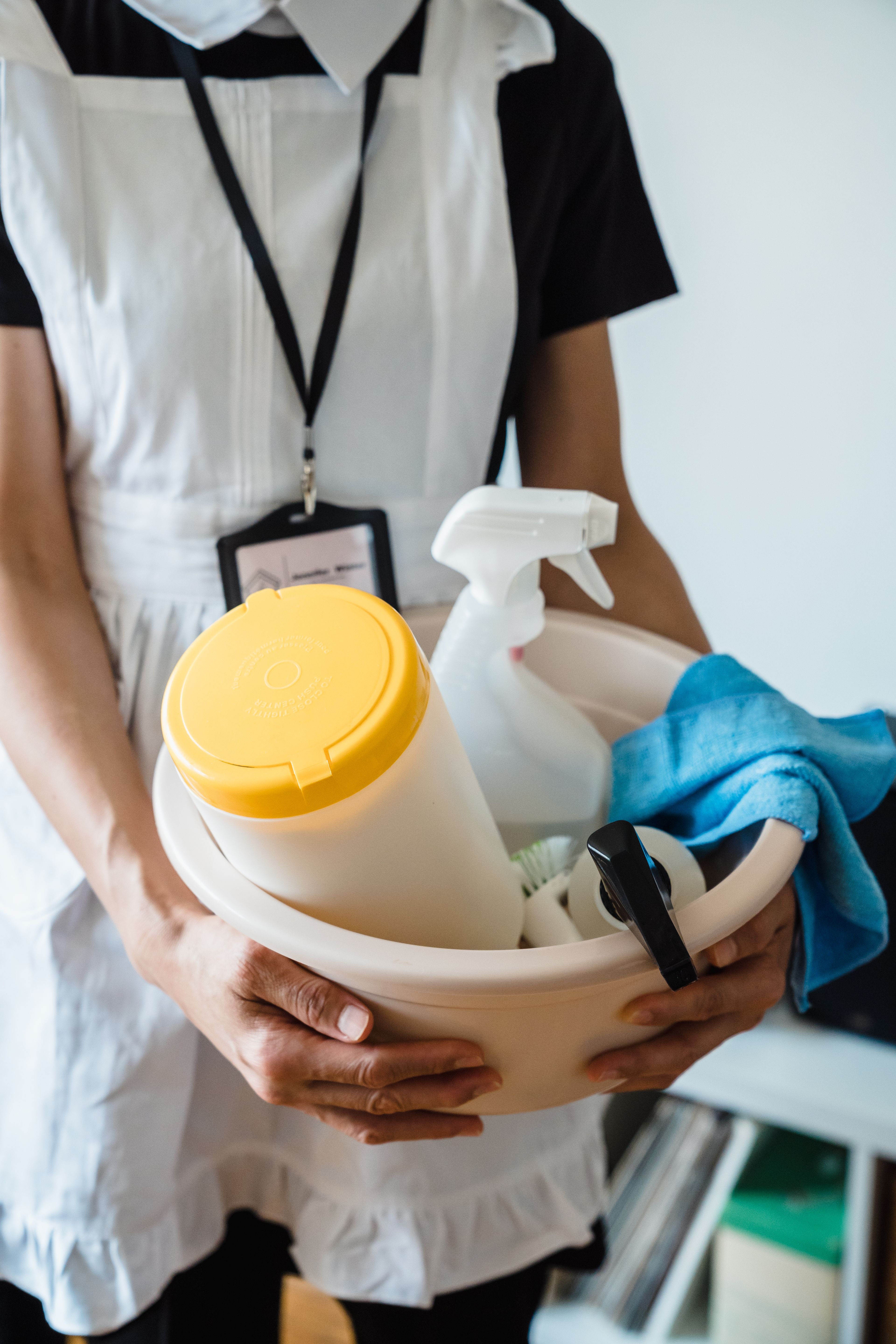 Dotation d'un agent Agent d'entretien en tenue portant une bassine remplie de produits et d'accessoires de nettoyage