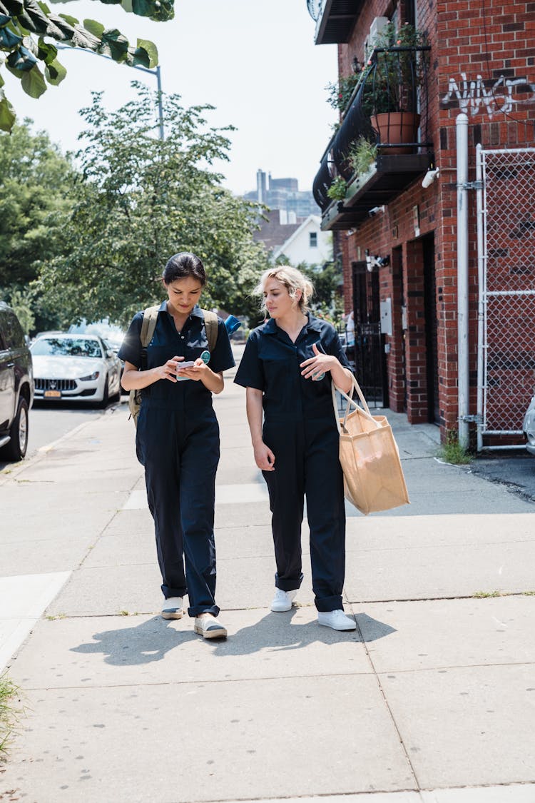 Two Women Walking In A City