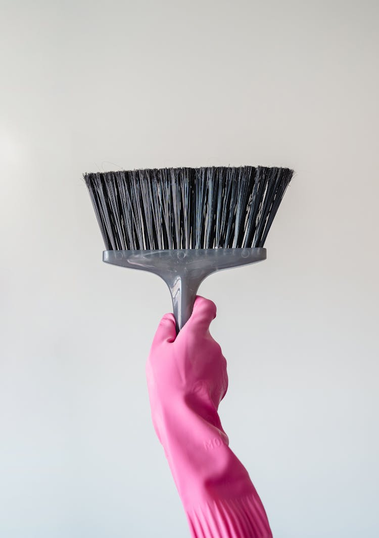 Hand In Pink Glove Holding Up Broom