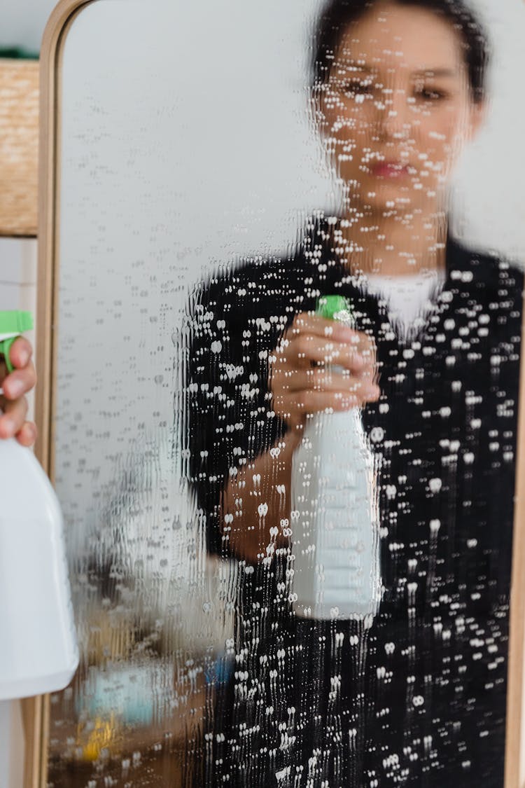 Reflection Of A Woman On Wet Mirror