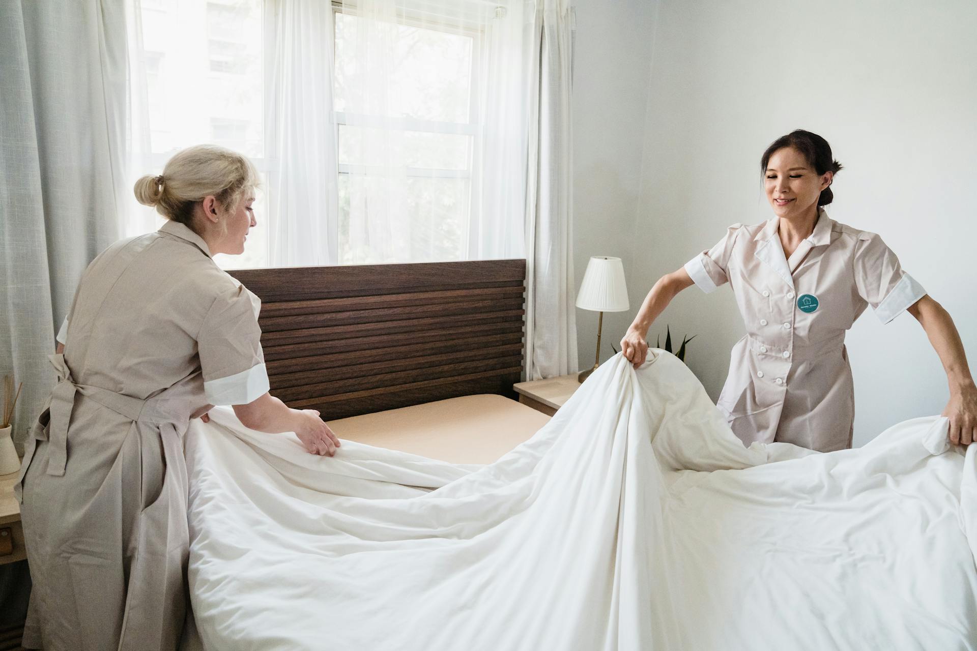 Housekeepers Changing Sheets in Hotel Room