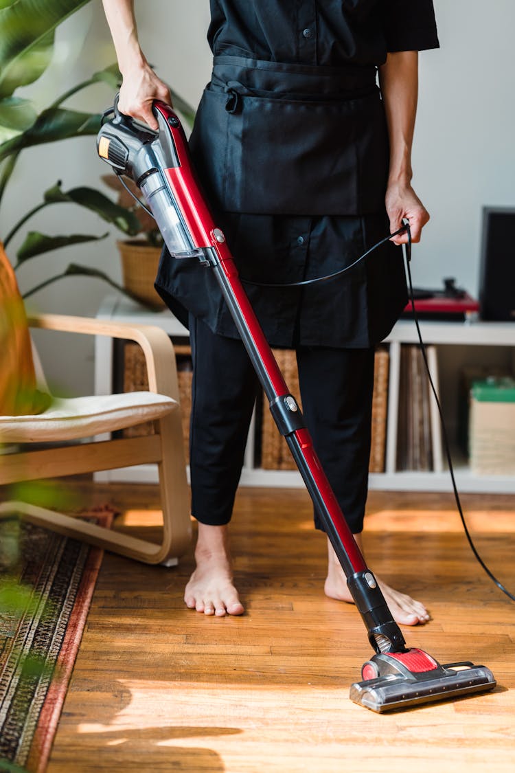 Person Vacuuming Wooden Floor