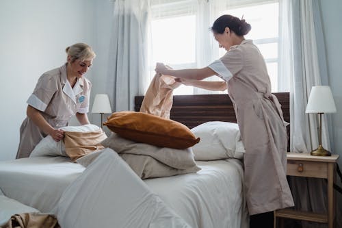 Free Two Women Fixing a Bed Together Stock Photo