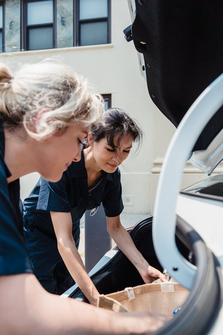 Women By Opened Trunk Of Car