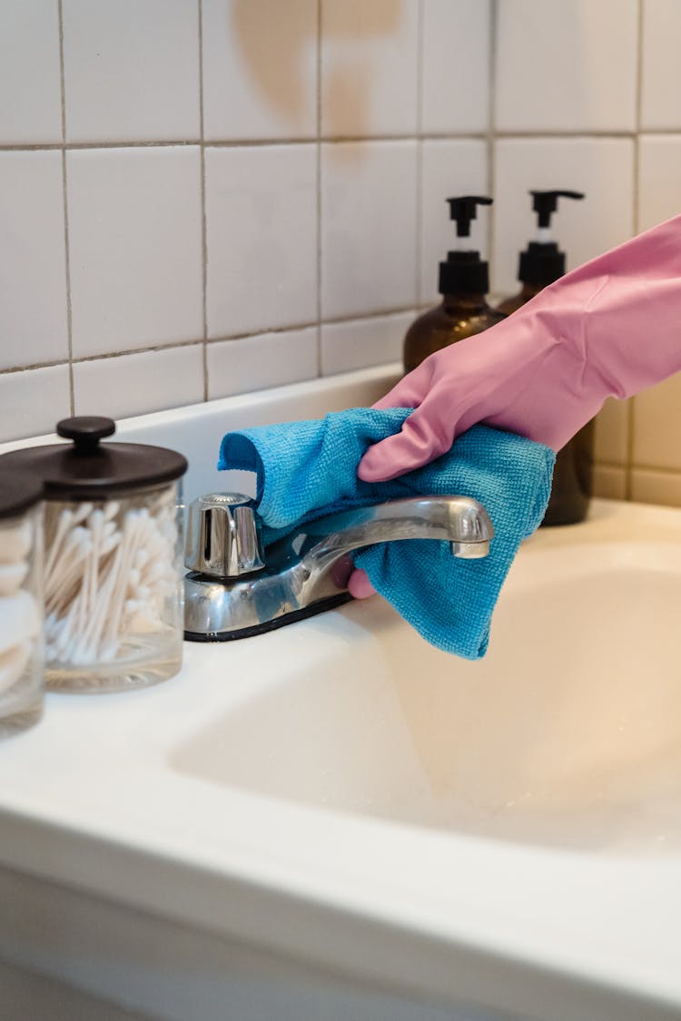 Gloved Hand Cleaning Faucet With Fiber Cloth