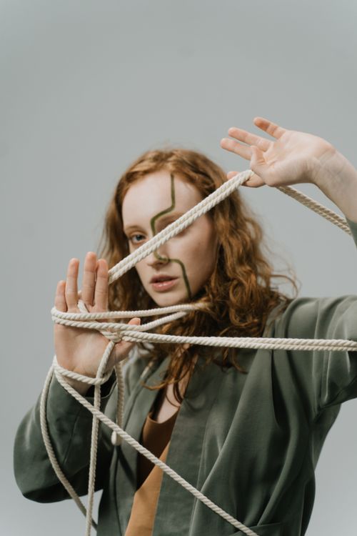 Free Artistic portrait of a woman with ropes symbolizing entanglement and freedom. Stock Photo