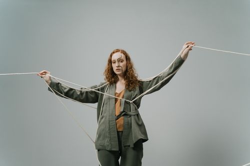 Free Portrait of a woman with ropes symbolizing entanglement on a gray background. Stock Photo