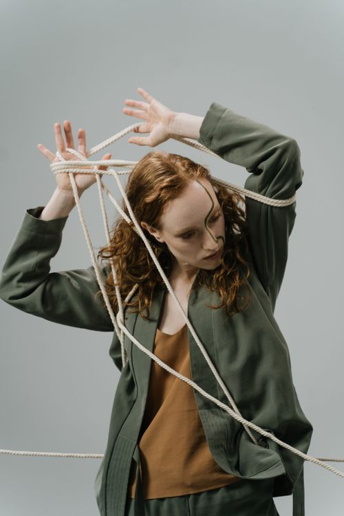 Free Studio shot of a woman tangled in ropes, conveying stress and mental health themes. Stock Photo