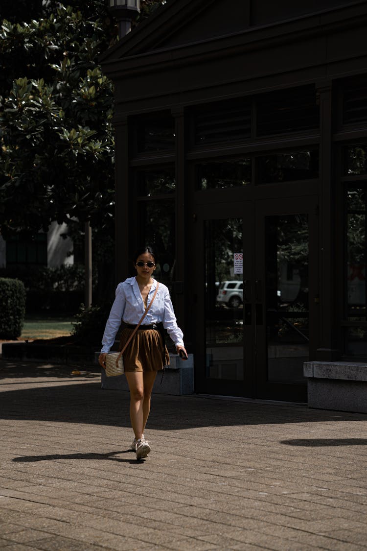 A Woman Walking Outside A Building