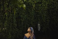 A woman sits in meditation amidst lush greenery, embodying peace and mindfulness in nature.