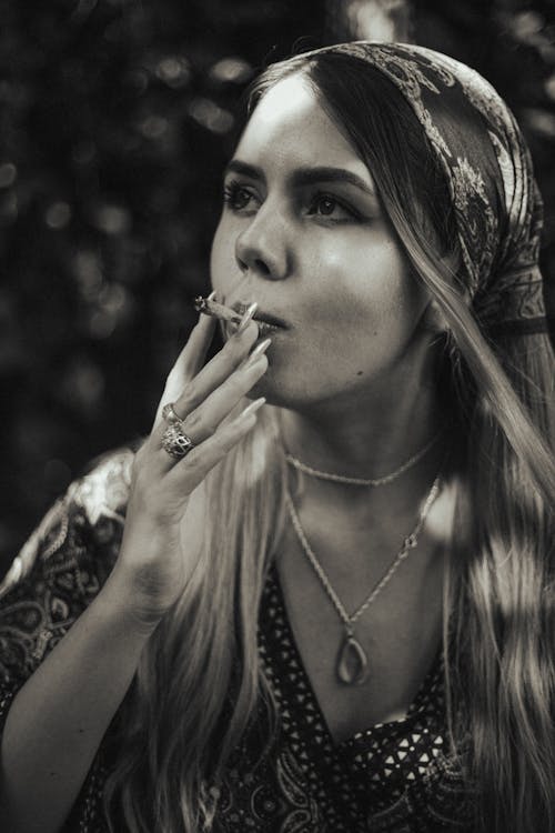 Grayscale Photo of a Woman Smoking a Joint