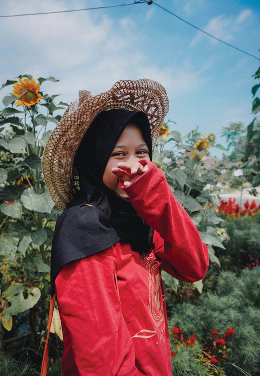 Young Woman In A Hijab And Hat Standing Among Flowers Free Stock Photo young-woman-in-a-hijab-and-hat-standing-among-flowers-free-stock-photo