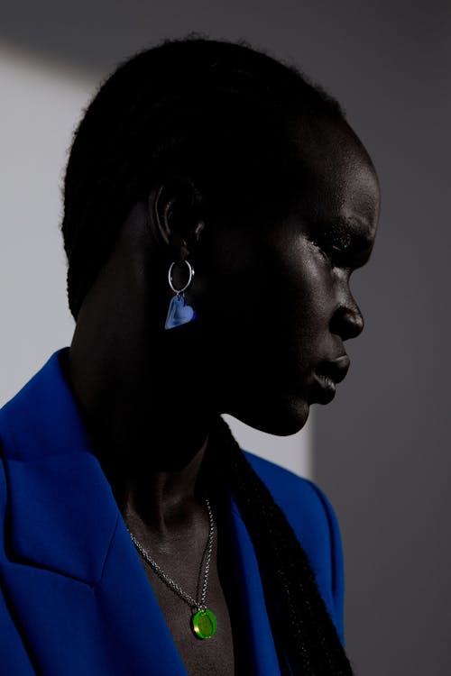Woman in Blue Blazer Wearing an Earring and a Necklace