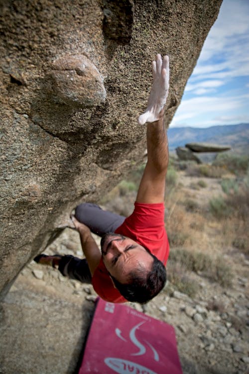 Free Man Climbing on Gray Concrete Peak at Daytime Stock Photo