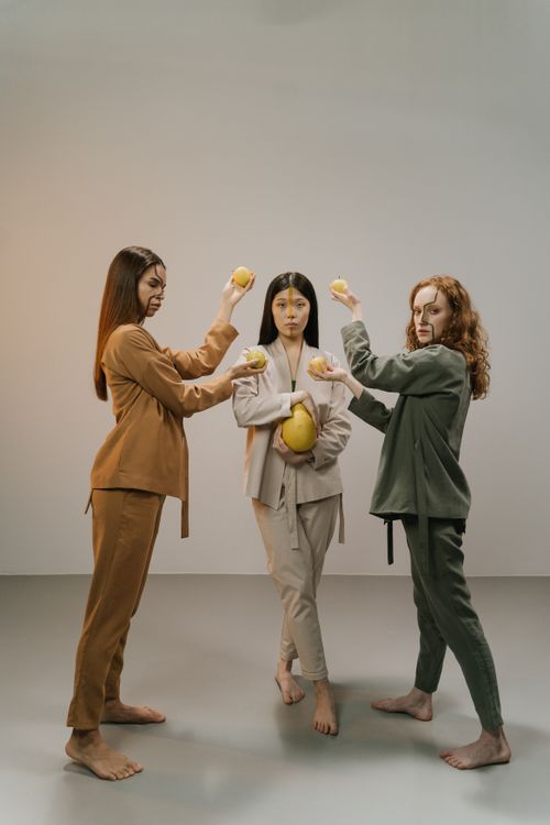 Free Artistic studio shot of three women creatively posed with lemons, showcasing diversity and fashion. Stock Photo