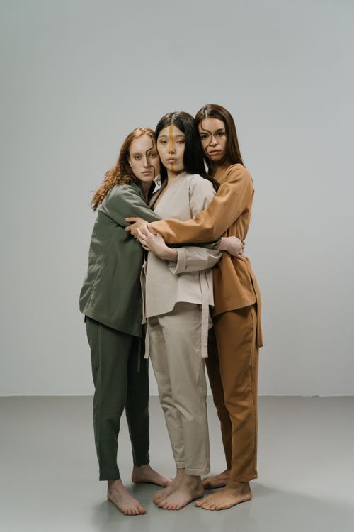 Free Three stylish diverse women embracing in a studio setting. Stock Photo