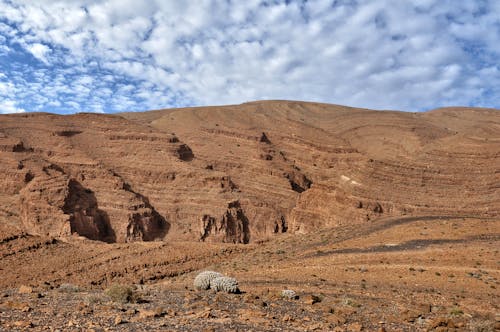 Brown Mountain Under A Blue and Cloudy Sky