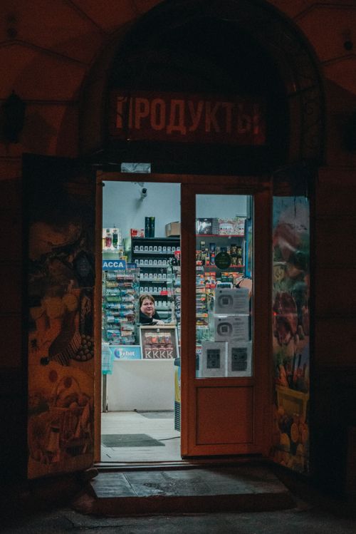 Free Evening view of a lit convenience store doorway showcasing a vibrant interior. Stock Photo