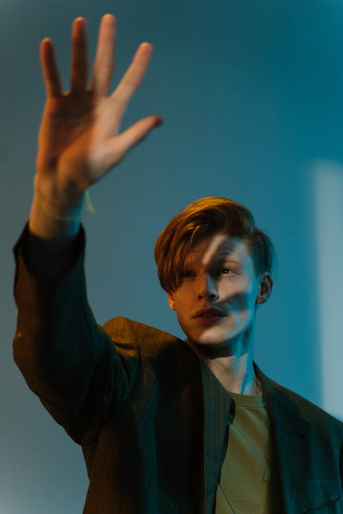 Man in Brown Suit Jacket Raising His Right Hand