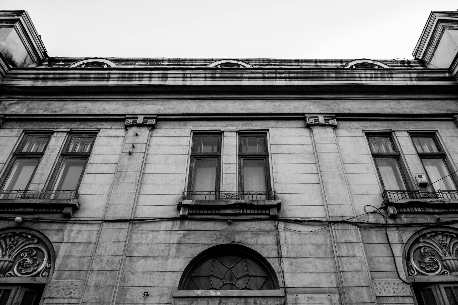 Black and white image of a historic building facade in Iași, Romania, showcasing architectural detail.