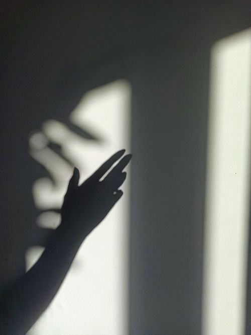 Free Shadow of a hand creating a pattern on a wall, beautifully capturing light and shadow interplay. Stock Photo