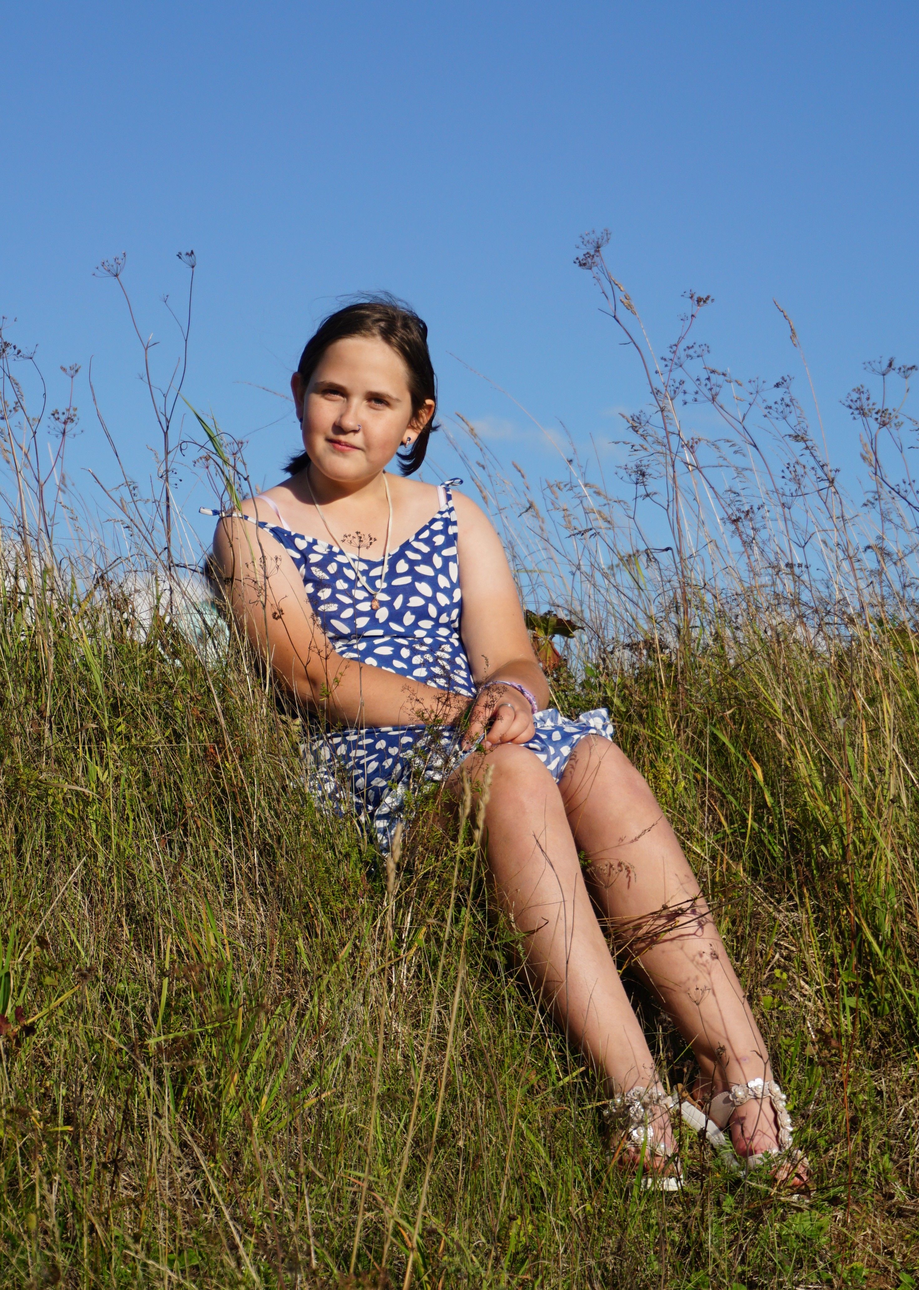 Woman in Blue and White Polka Dot Dress Sitting on Green Grass · Free ...