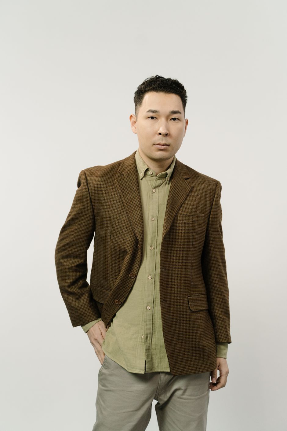 Model in a checked wool blazer against a pale studio wall — photo by Ron Lach on Pexels