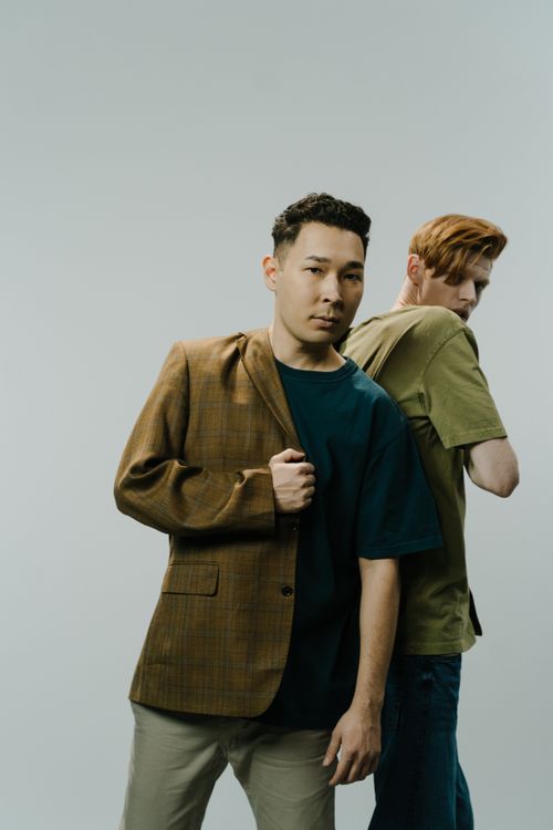 Free A conceptual fashion portrait of two stylish men in a studio setting, showcasing modern fashion trends. Stock Photo