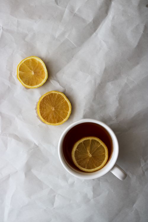 Free Artistic top view of lemon slice tea in a white mug on crumpled paper. Stock Photo