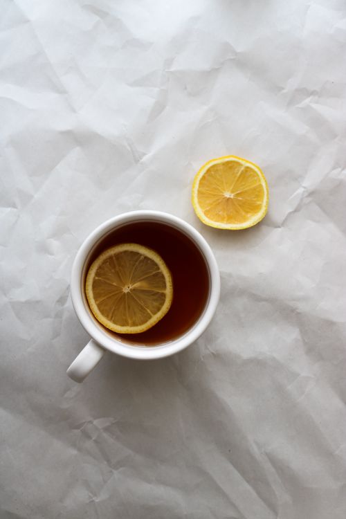 Free High-angle shot of a cup of tea with lemon slice on a textured white background. Stock Photo
