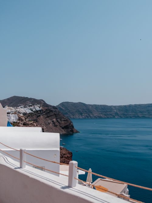 Free Experience the breathtaking views of the Santorini coastline with clear blue skies and serene waters. Stock Photo