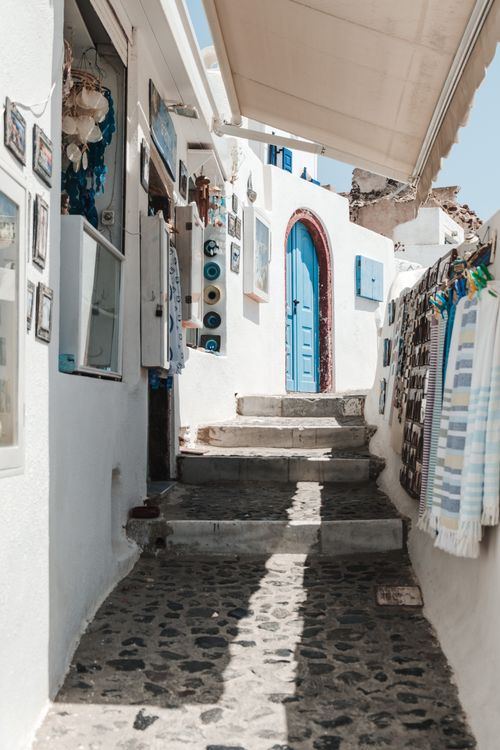 Free Picturesque alleyway featuring a blue door and traditional architecture in a Mediterranean town. Stock Photo