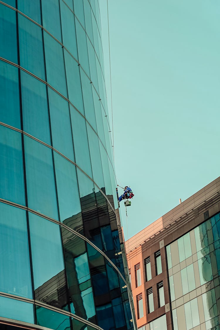 A Person Cleaning Glass Building