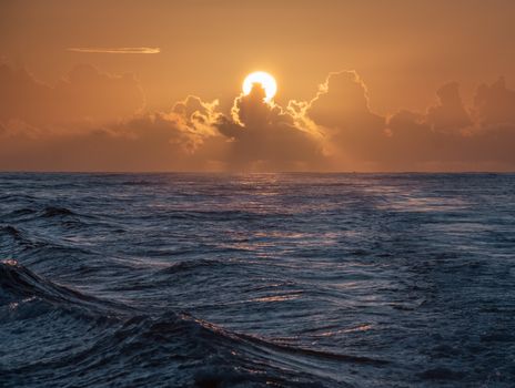 Stunning ocean sunset with dramatic clouds and vibrant warm colors over the horizon.