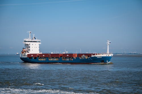 Blue and Red Cargo Ship on Sea Under Blue Sky