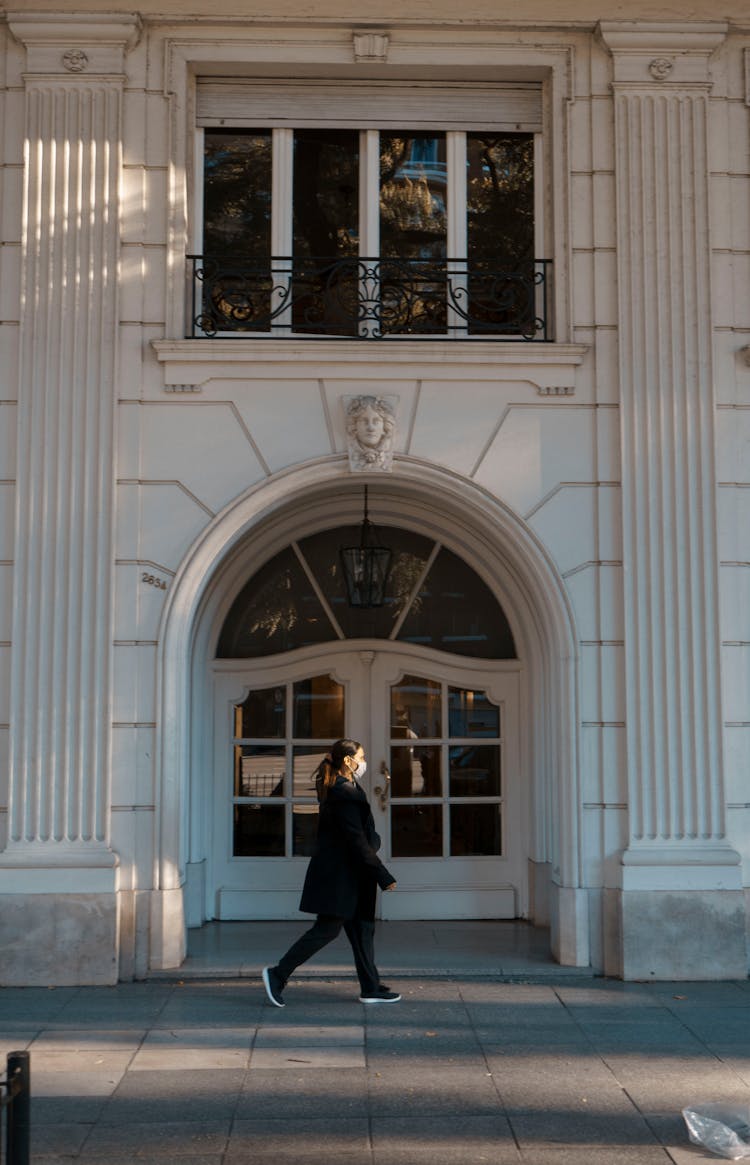 Side View Of A Woman Walking On Sidewalk