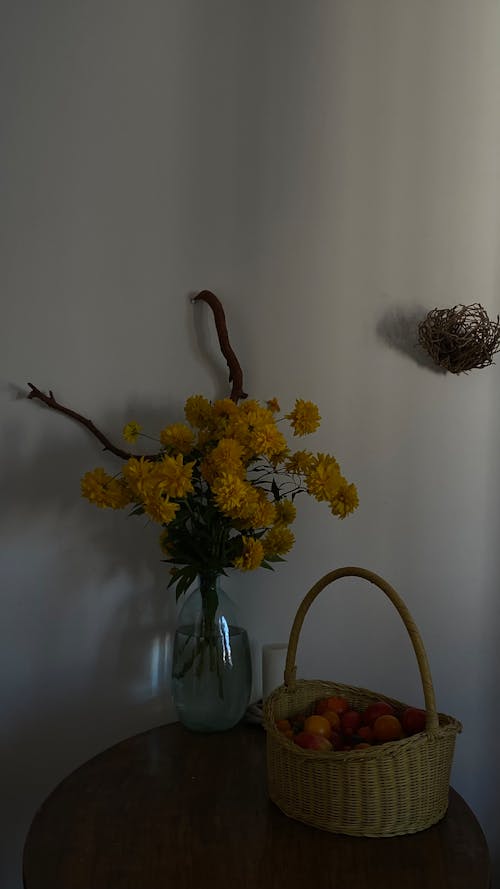 Flowers in a Vase Beside a Basket of Fruits