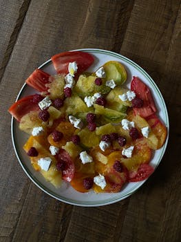 A bright and healthy summer salad featuring heirloom tomatoes, goat cheese, and fresh raspberries.