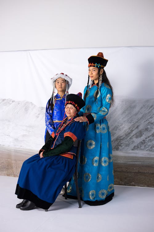 2 Women in Blue and Brown Traditional Dress Standing on Snow Covered Ground