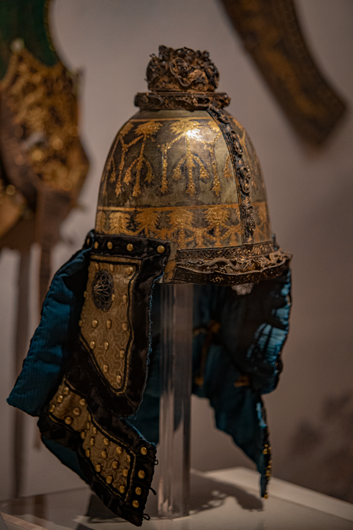 Free Close-up of an ornate medieval helmet with intricate patterns, displayed in a museum setting. Stock Photo
